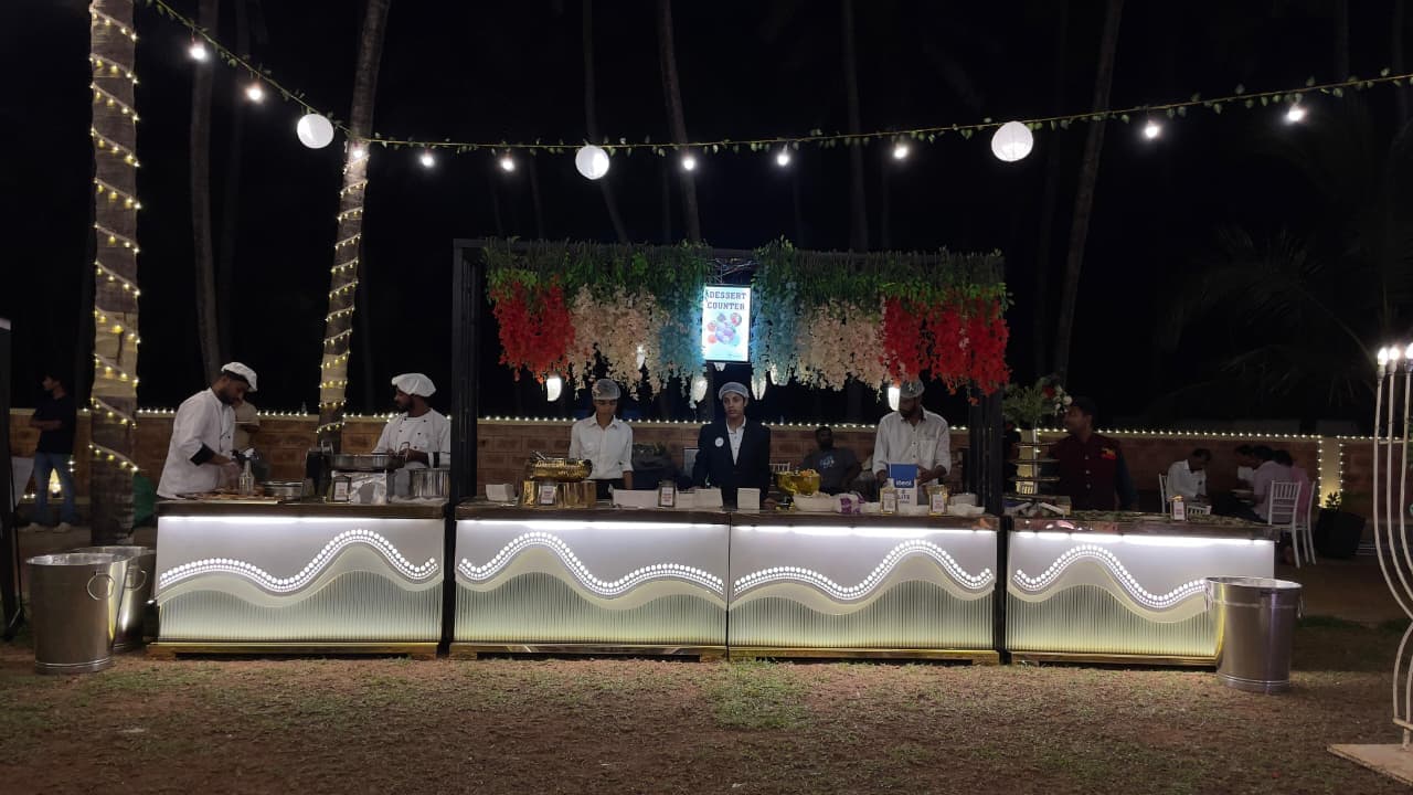 Outdoor dessert counter with LED wave design at a Shanvi Caterers event