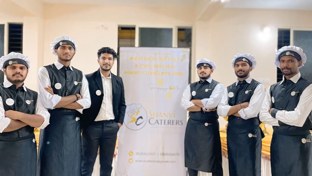 Shanvi Caterers professional team posing with branded banner at a Mangalore event
